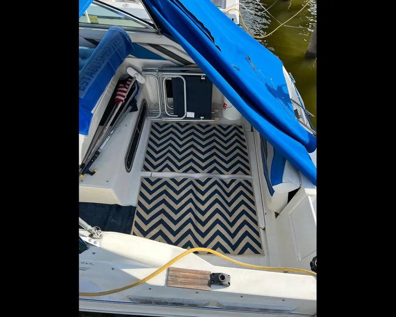 Slide: The Image of 1991 Sea Ray Sundancer 220 interior with blue canopy and chevron-patterned flooring. - 3