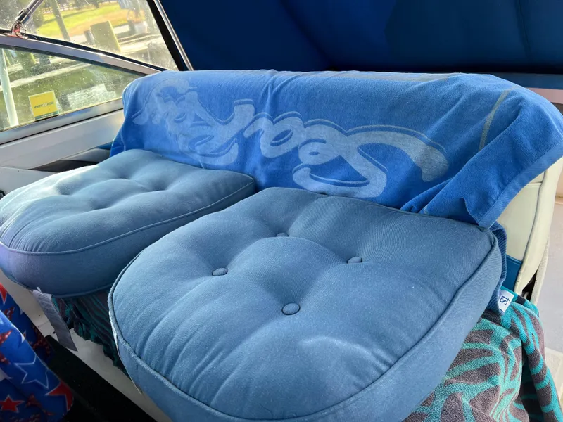 Slide: The Image of Interior of 1991 Sea Ray Sundancer 220 with blue cushions and towel. - 6
