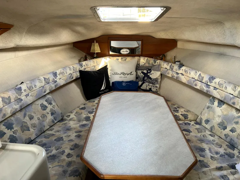 Slide: The Image of 1991 Sea Ray Sundancer 220 cabin interior with floral upholstery and table. - 8