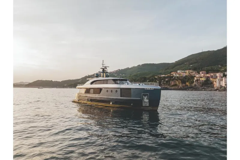 Slide: The Image of Azimut Magellano 30M 2023 yacht cruising near coastal hills at sunset. - 30