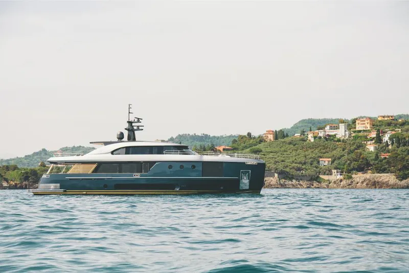 Slide: The Image of 2023 Azimut Magellano 30M yacht cruising near a coastal village. - 6