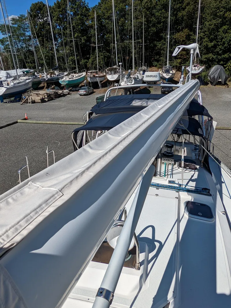 Slide: The Image of 1995 Freedom 40/40 sailboat docked, surrounded by other boats and trees in the background. - 11