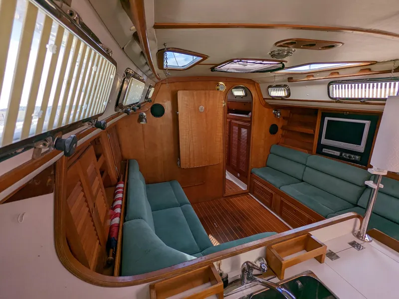Slide: The Image of Interior of a 1995 Freedom 40/40 yacht with wood paneling and green seating. - 12