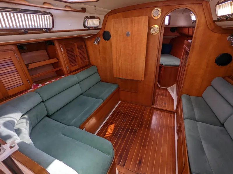 Slide: The Image of Interior of a 1995 Freedom 40/40 sailboat with wooden finishes and green seating. - 13