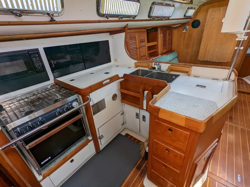 Slide: The Image of Interior of a 1995 Freedom 40/40 yacht kitchen with wood cabinetry and modern appliances. - 15
