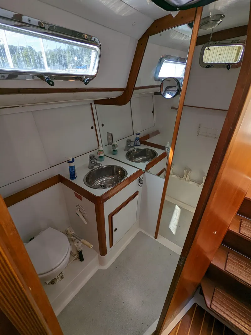 Slide: The Image of 1995 Freedom 40/40 yacht bathroom with dual sinks, toilet, and wooden accents. - 17