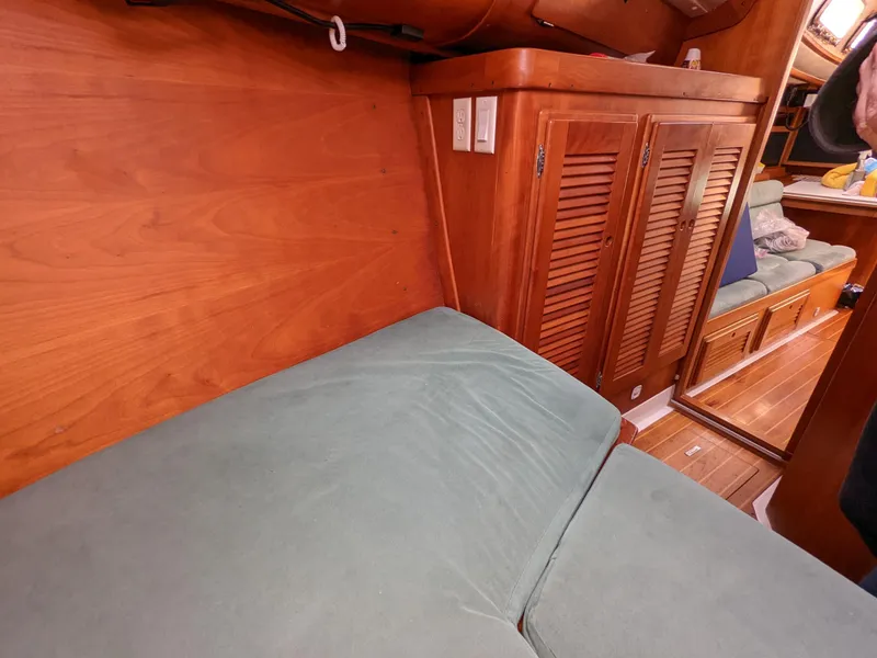 Slide: The Image of Cozy interior of a 1995 Freedom 40/40 sailboat with wooden cabinetry and cushioned seating. - 19