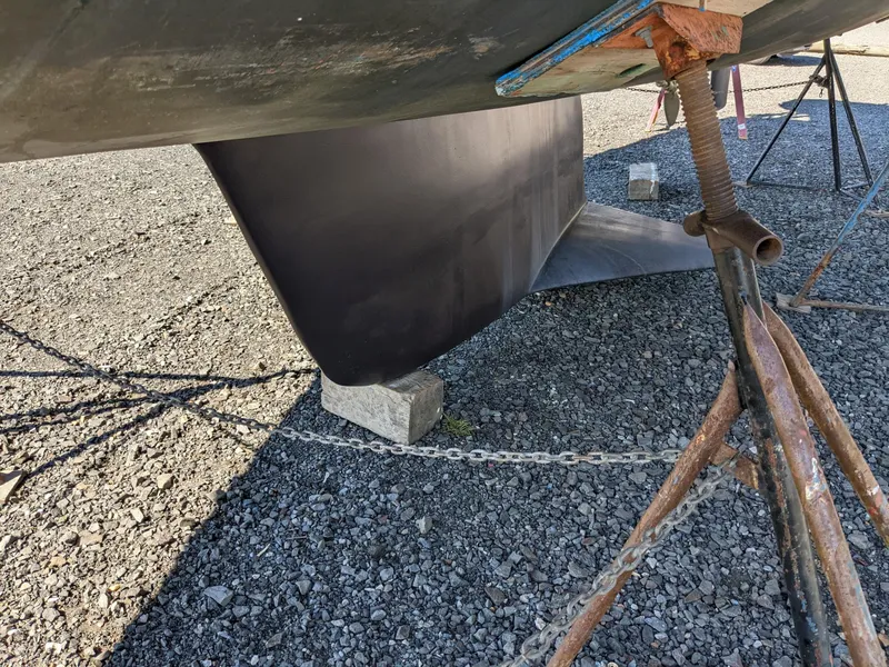 Slide: The Image of Keel of a 1995 Freedom 40/40 sailboat supported by stands on gravel. - 4
