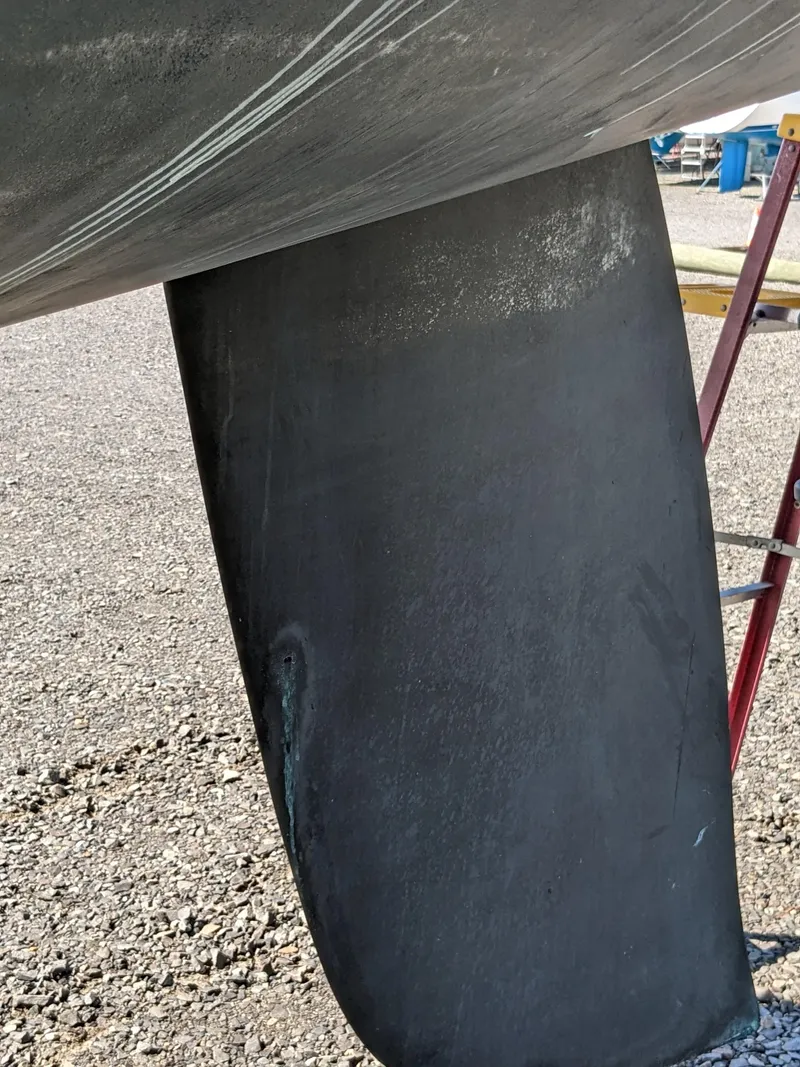 Slide: The Image of Close-up of a 1995 Freedom 40/40 sailboat keel on gravel surface. - 6