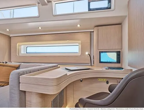 Slide: The Image of Luxurious interior of 2026 Beneteau Oceanis Yacht 60 with modern desk and seating. - 14