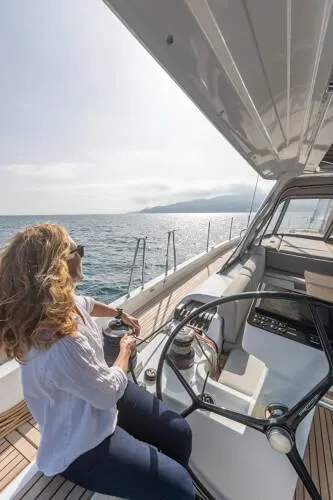 Slide: The Image of Woman sailing Beneteau Oceanis Yacht 60, 2026 model, on open sea. - 7