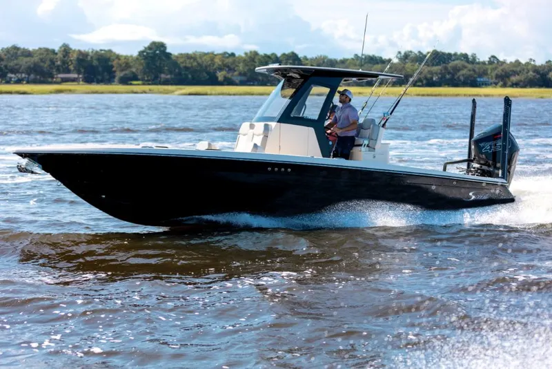 Slide: The Image of 2023 Scout 281 XSS boat cruising on a lake. - 10