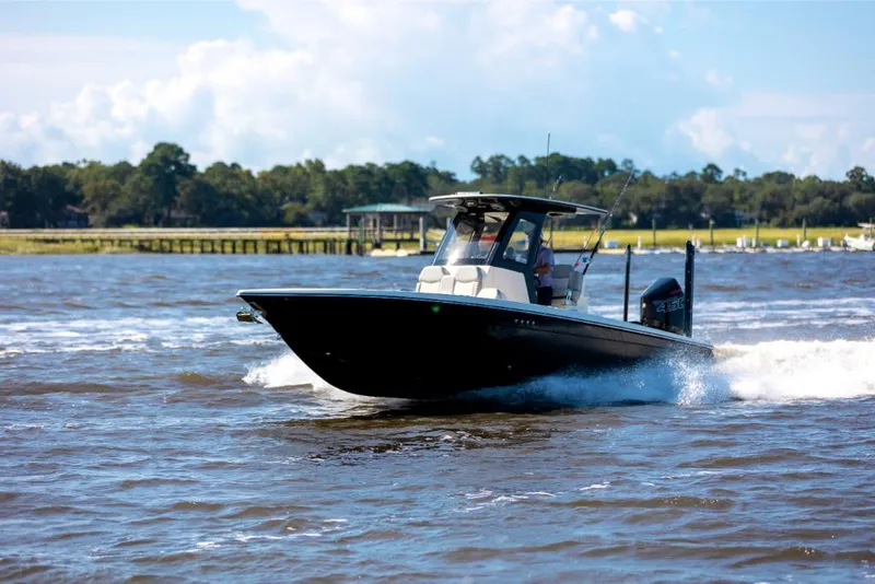 Slide: The Image of 2023 Scout 281 XSS boat cruising on a lake with scenic background. - 11