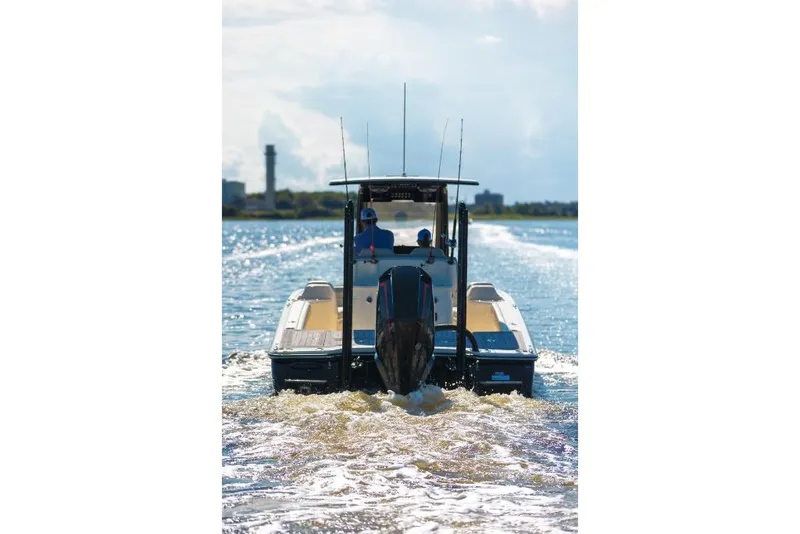 Slide: The Image of 2023 Scout 281 XSS boat cruising on water, rear view - 14