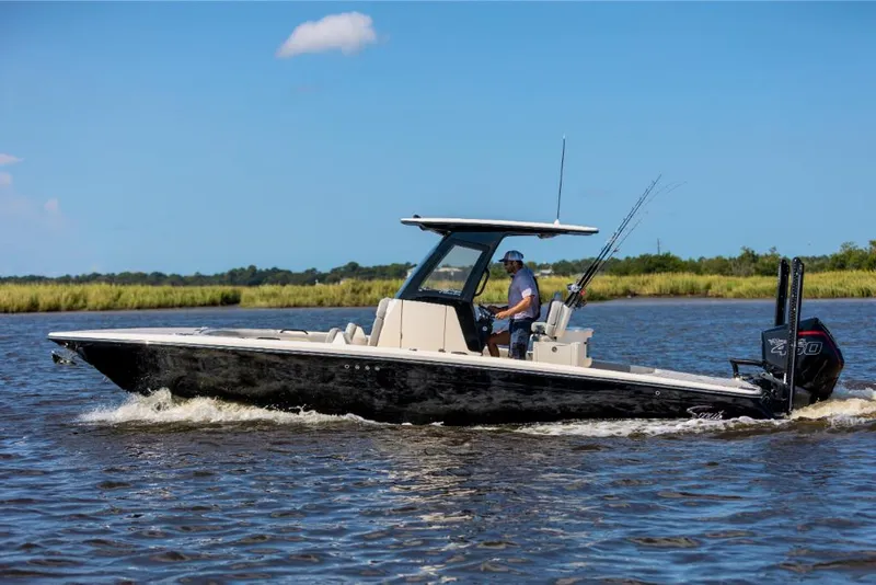 Slide: The Image of 2023 Scout 281 XSS boat cruising on a river with a person at the helm. - 18
