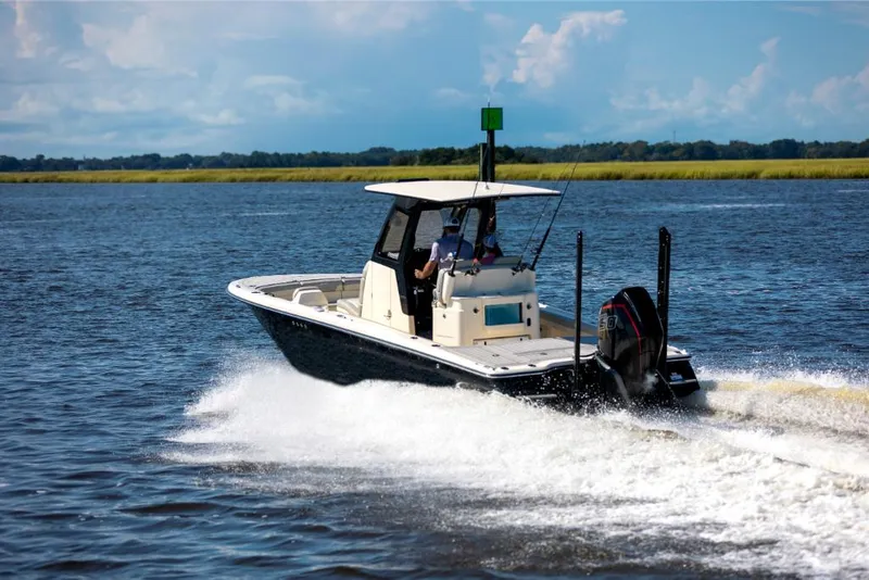 Slide: The Image of 2023 Scout 281 XSS boat cruising on a lake with a scenic background. - 19