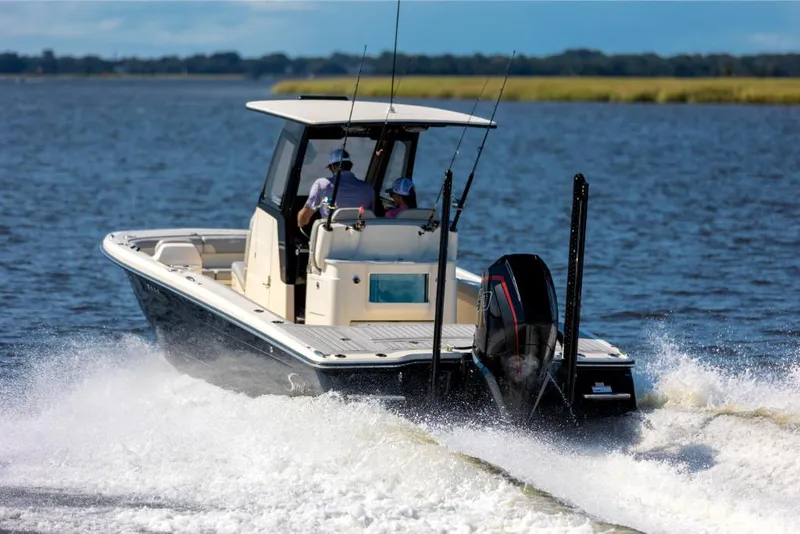 Slide: The Image of 2023 Scout 281 XSS boat cruising on a lake with two passengers. - 21