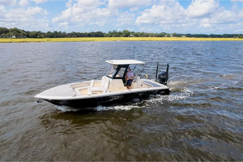 Slide: The Image of 2023 Scout 281 XSS boat cruising on a lake under a blue sky. - 26