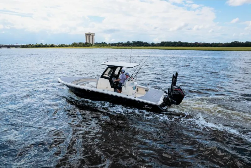 Slide: The Image of 2023 Scout 281 XSS boat cruising on a scenic river. - 31