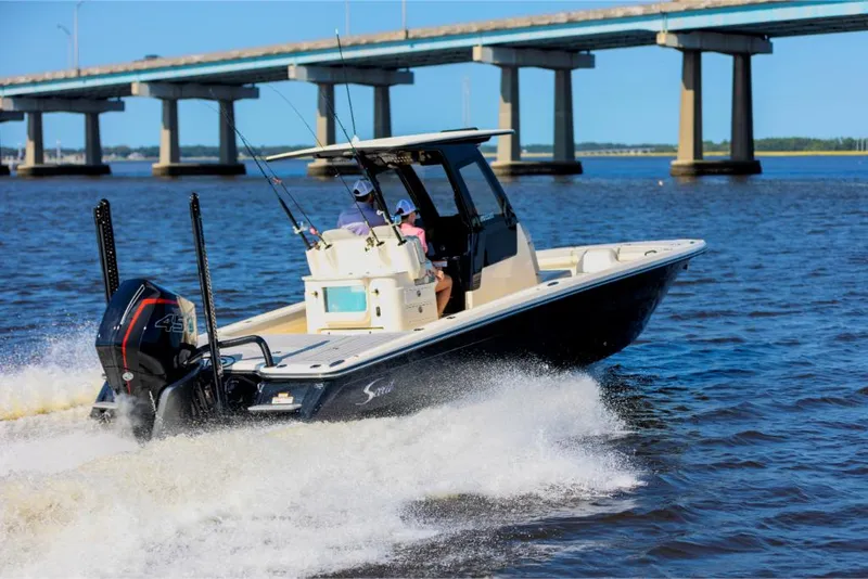 Slide: The Image of 2023 Scout 281 XSS boat cruising on water near a bridge. - 6