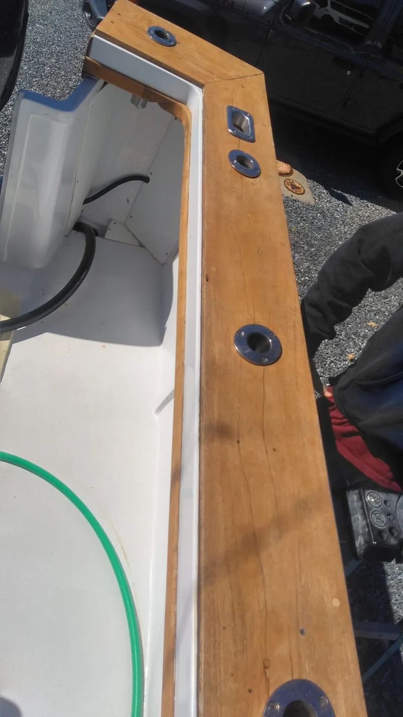 Slide: The Image of 1986 Blackfin 27 Cuddy boat deck with wooden finish and rod holders. - 8