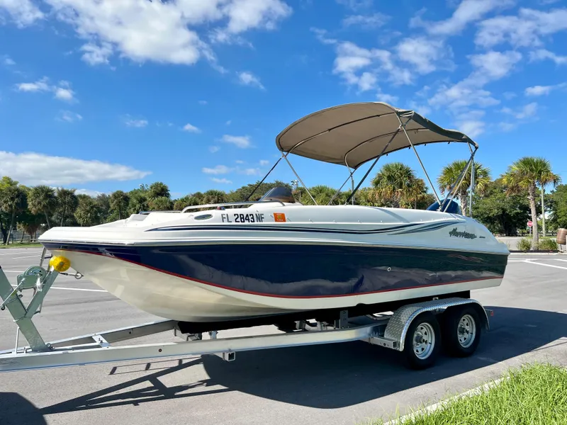 Slide: The Image of 2006 Hurricane 194 boat on trailer under blue sky with palm trees. - 12