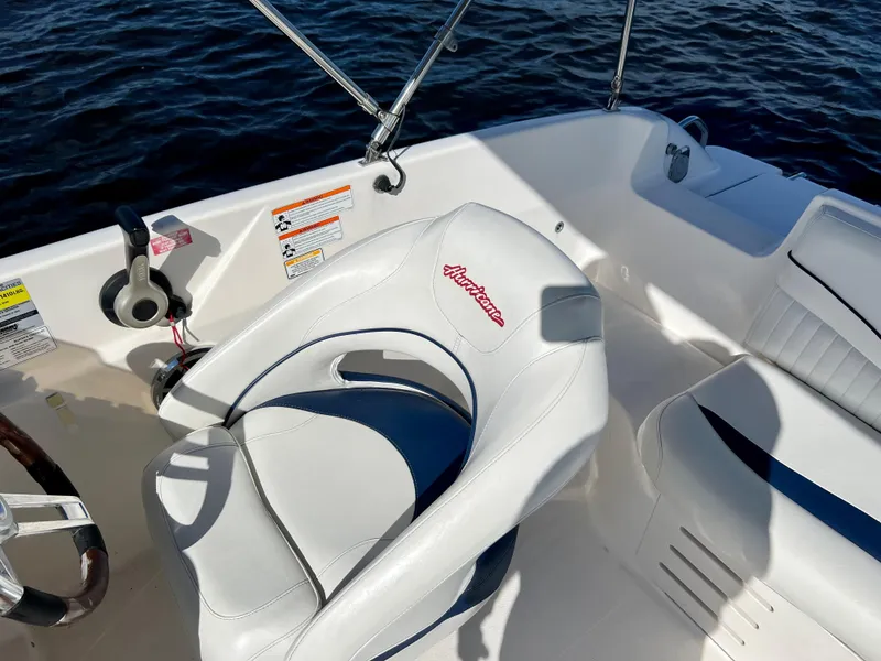 Slide: The Image of Hurricane 194 boat interior, 2006 model, featuring white seating and steering wheel on water. - 22