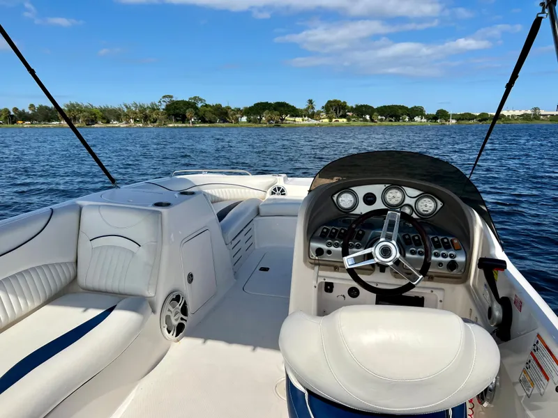 Slide: The Image of 2006 Hurricane 194 boat interior with steering wheel, white seating, and lake view. - 25