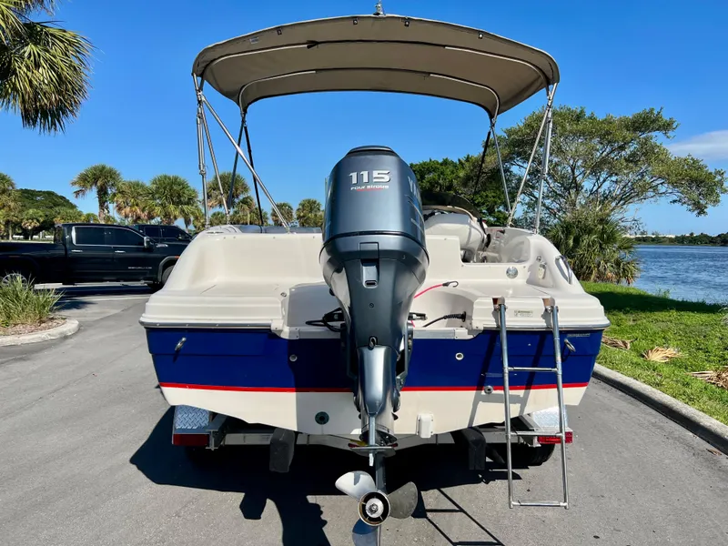 Slide: The Image of 2006 Hurricane 194 boat with Yamaha 115 outboard motor, parked near a scenic lake. - 3