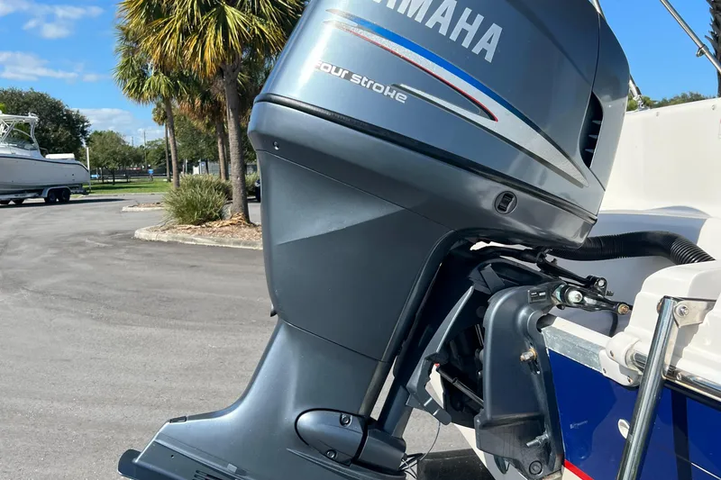 Slide: The Image of Yamaha four-stroke outboard motor on a 2006 Hurricane 194 boat, parked near palm trees. - 33