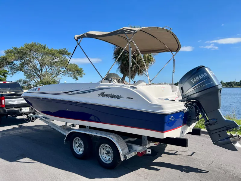Slide: The Image of 2006 Hurricane 194 boat with Yamaha motor on trailer by a lake. - 4