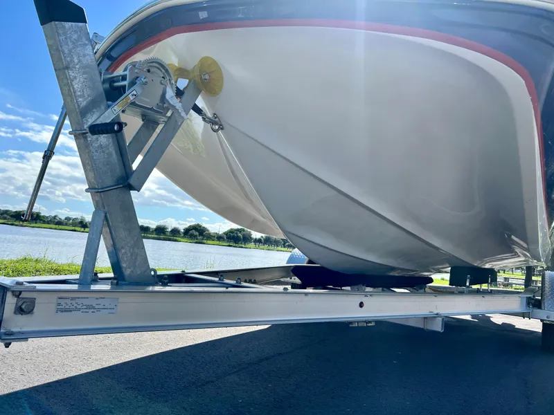 Slide: The Image of 2006 Hurricane 194 boat on trailer by a lake under a clear blue sky. - 7