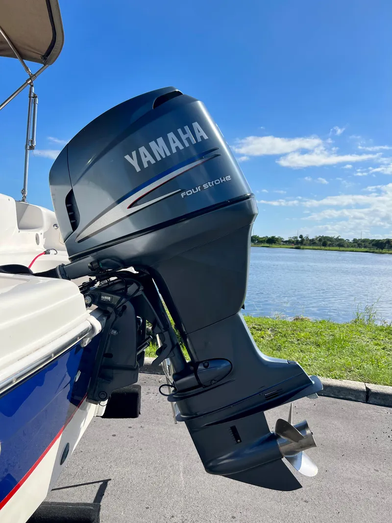 Slide: The Image of Yamaha four-stroke outboard motor on 2006 Hurricane 194 boat by a lake. - 8