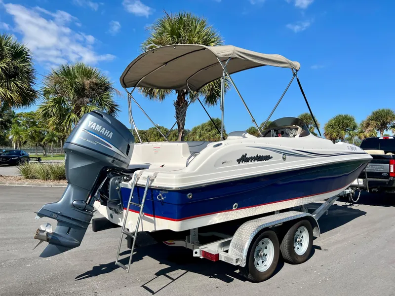 Slide: The Image of 2006 Hurricane 194 boat with Yamaha motor on trailer, parked under sunny skies. - 9
