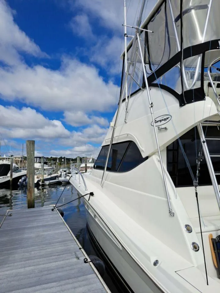 Slide: The Image of 2005 Rampage 45 Convertible yacht docked under blue sky. - 23