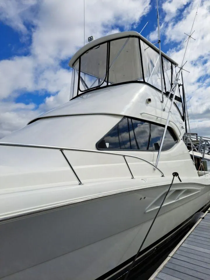 Slide: The Image of 2005 Rampage 45 Convertible yacht docked, blue sky. - 24