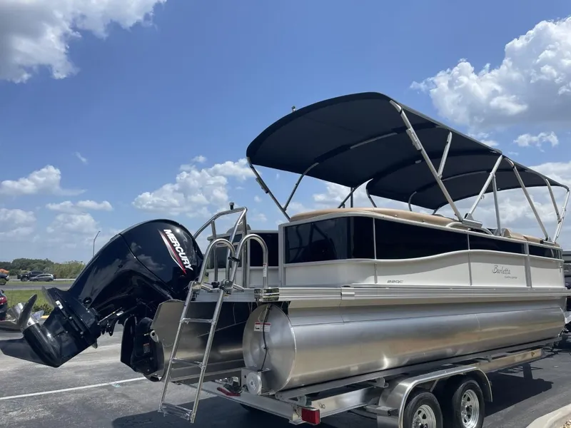 Slide: The Image of 2022 Barletta Cabrio 22QC pontoon boat with Mercury engine on trailer under blue sky. - 3