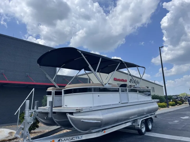 Slide: The Image of 2022 Barletta Cabrio 22QC pontoon boat on trailer, parked outside dealership under blue sky. - 4