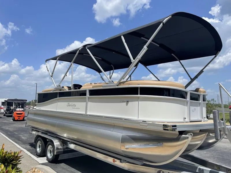 Slide: The Image of 2022 Barletta Cabrio 22QC pontoon boat with canopy on trailer, under blue sky. - 5