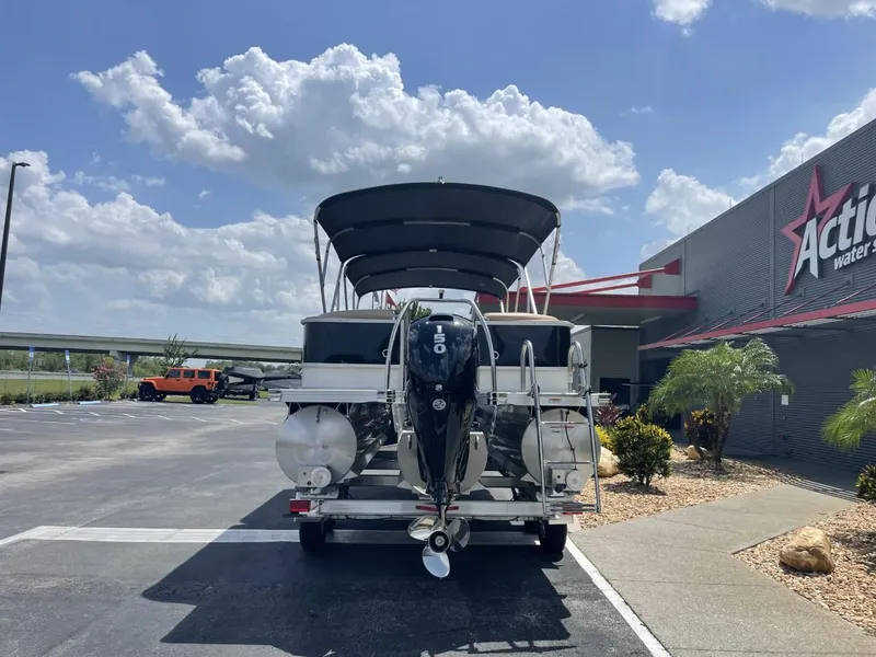 Slide: The Image of 2022 Barletta Cabrio 22QC pontoon boat parked outside dealership under blue sky. - 7