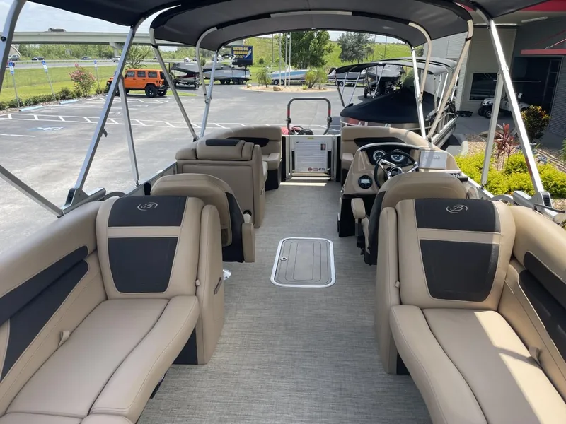 Slide: The Image of 2022 Barletta Cabrio 22QC pontoon boat interior with beige seating and steering console. - 9