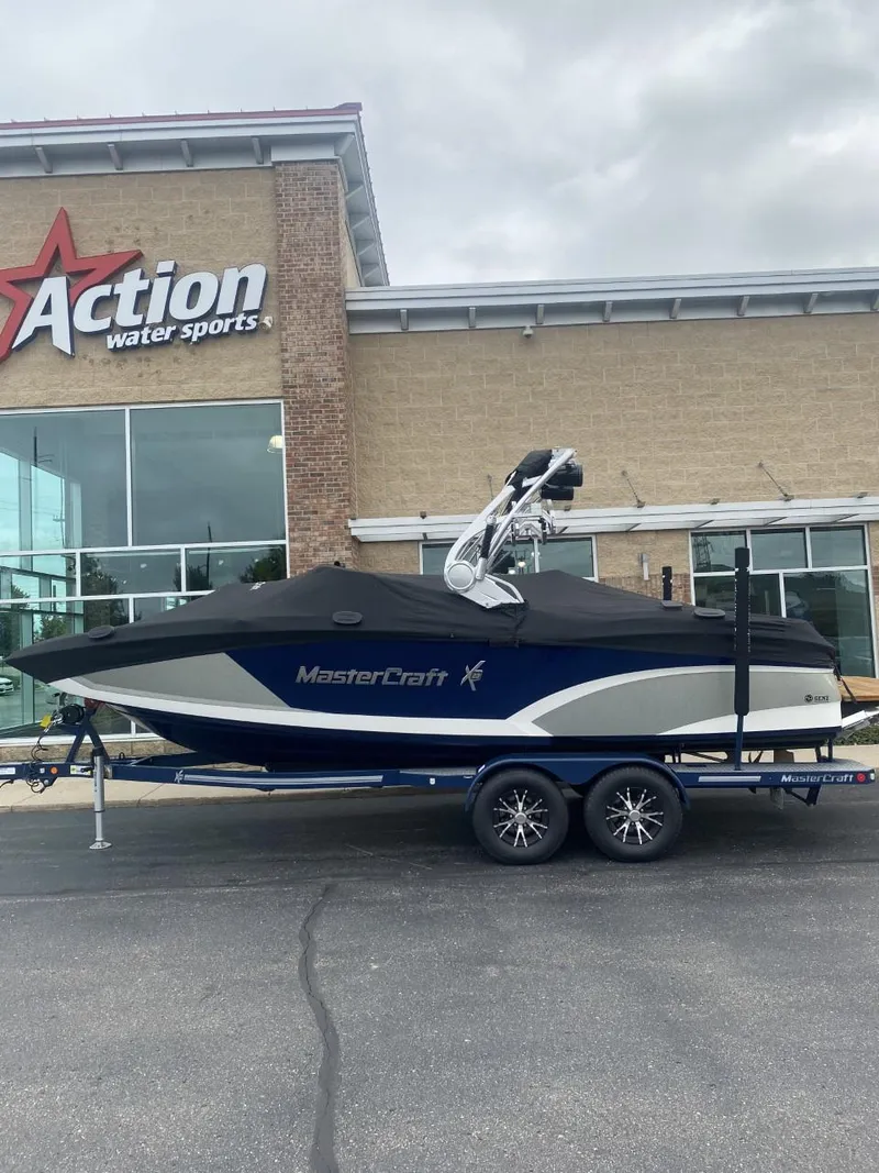 Slide: The Image of 2016 MasterCraft X23 boat on trailer outside Action Water Sports store. - 5