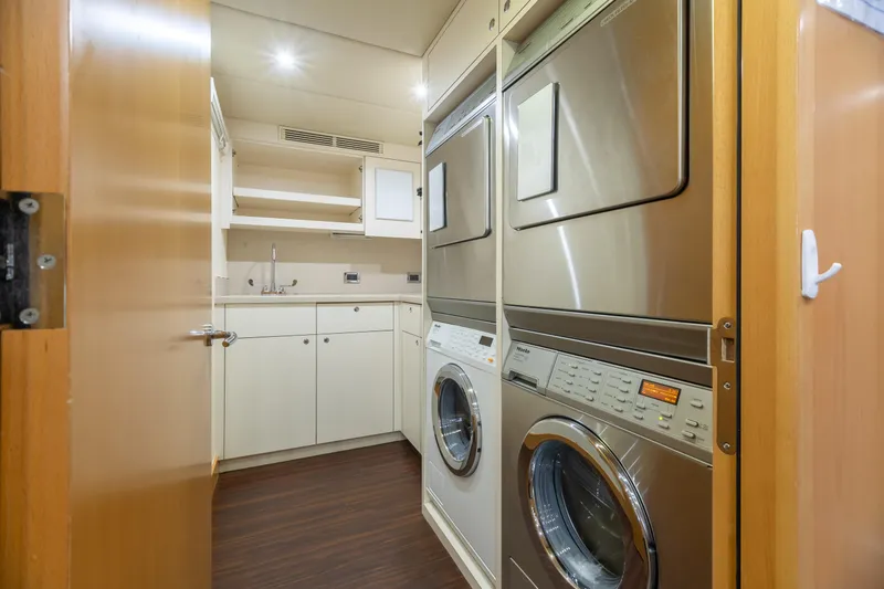 Slide: The Image of Laundry room on 2011 Trinity Yachts CUSTOM with stacked washer and dryer units. - 48