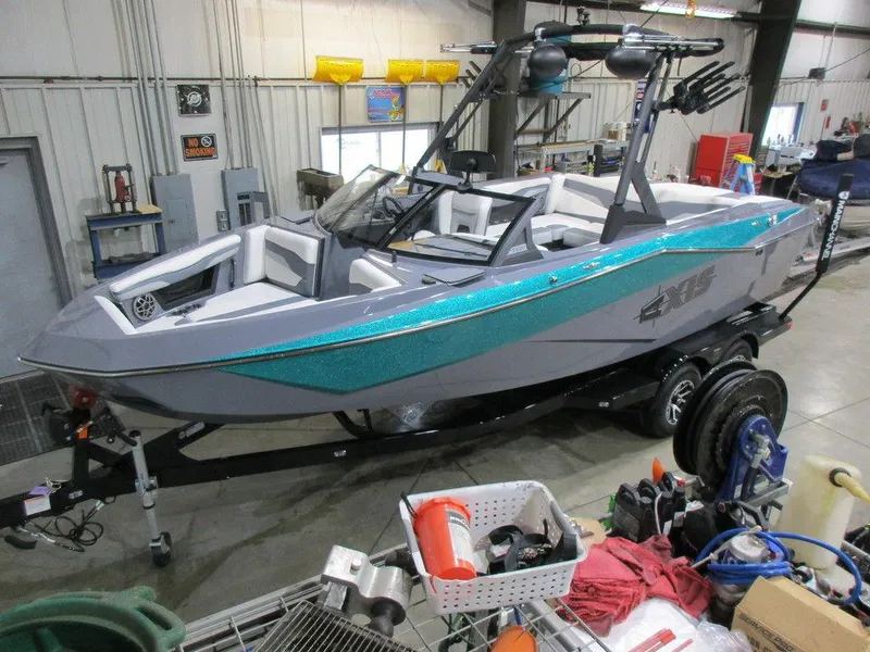 Slide: The Image of 2023 Axis T220 boat in a workshop, teal and gray color scheme. - 0