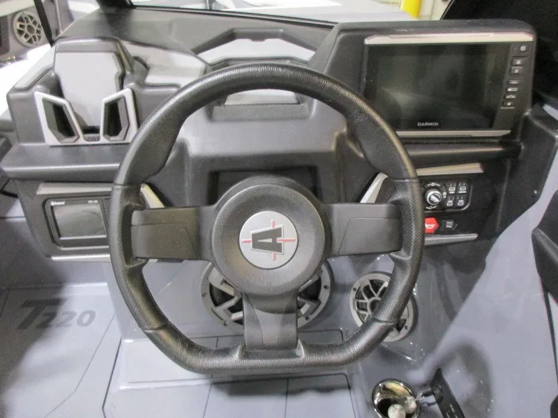 Slide: The Image of 2023 Axis T220 boat dashboard with steering wheel and Garmin display. - 13