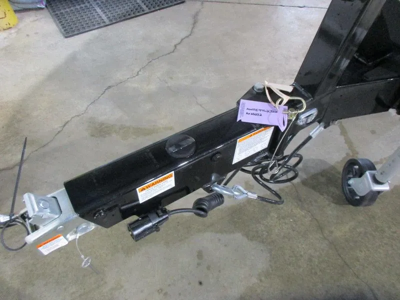 Slide: The Image of Axis T220 trailer hitch, 2023 model, black, with safety labels and wiring. - 6