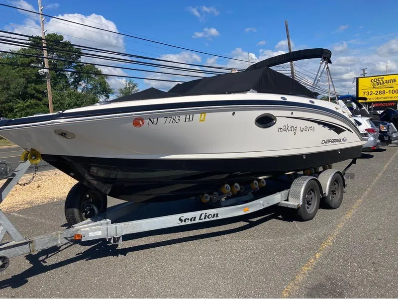 Slide: The Image of 2018 Chaparral 244 Sunesta boat on trailer, parked outdoors under blue sky. - 12