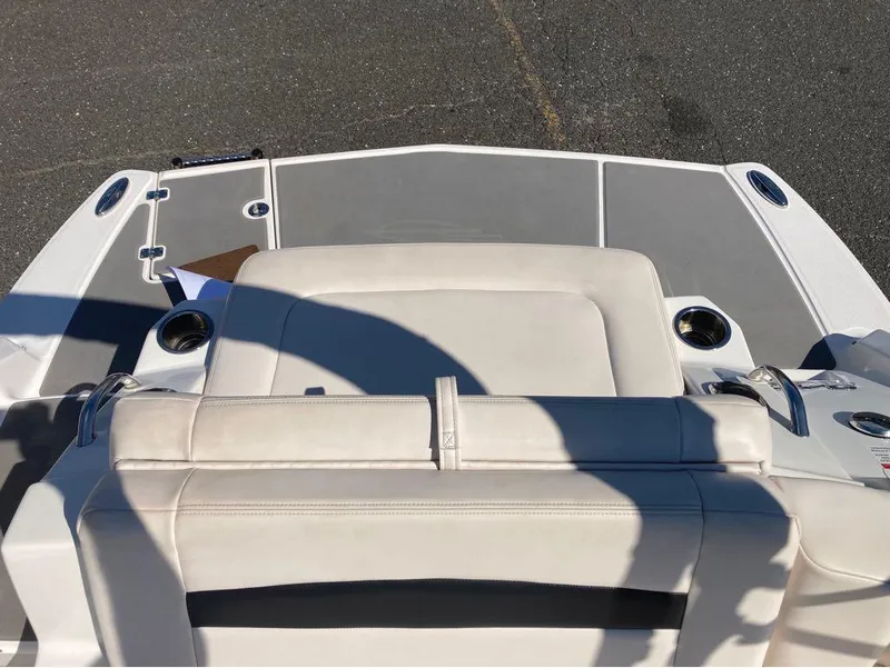 Slide: The Image of 2018 Chaparral 244 Sunesta boat interior with beige seating and cup holders. - 9