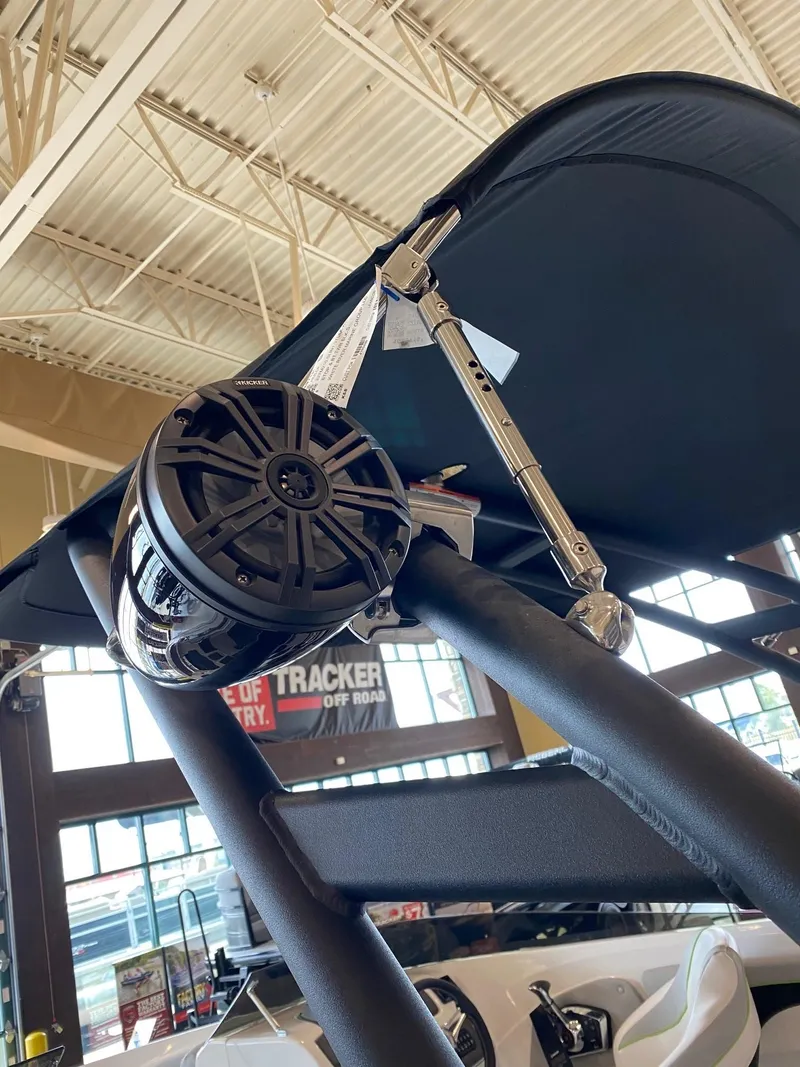 Slide: The Image of 2023 Tahoe 210 Si Limited boat with speaker and canopy in showroom. - 5