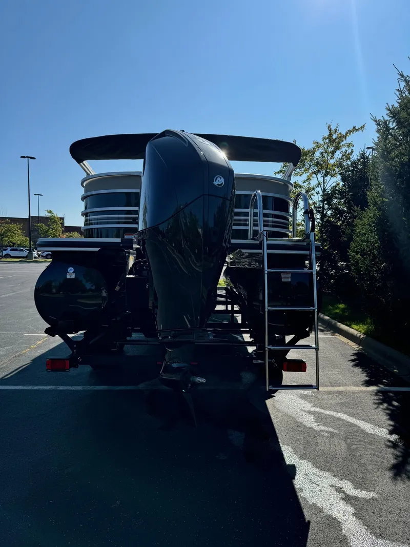 Slide: The Image of 2023 Ranger Reata 243C boat with powerful outboard motor in a parking lot. - 5